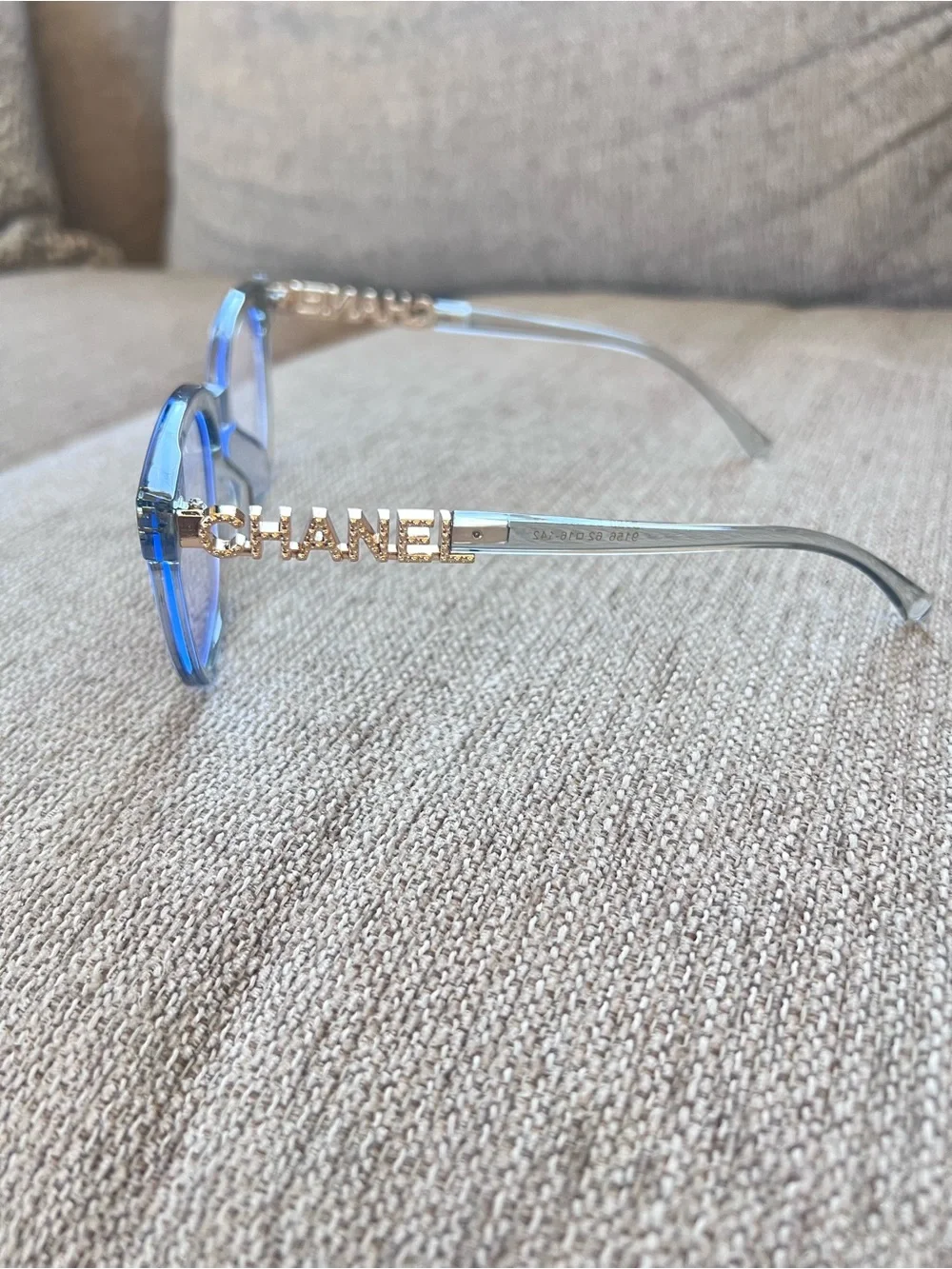 CHANEL Transparent Light Blue Frame Glasses with Gold Logos